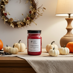 Load image into Gallery viewer, Red hand poured candle labeled 'Dragon's Blood' on a table with pumpkins and a wreath in the background. Southern Charm Farmhouse.
