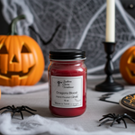 Load image into Gallery viewer, Red hand poured candle in a 16 oz mason jar labeled 'Dragons Blood' on a Halloween-themed table with pumpkins and spiders. Southern Charm Farmhouse.
