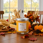 Load image into Gallery viewer, A hand poured scented candle in a clear glass jar with a silver lid sits on a wooden table surrounded by autumn decorations including pumpkins, corn, cinnamon sticks, and fallen leaves. The candle label reads 'Fall Festival'. Southern Charm Farmhouse.
