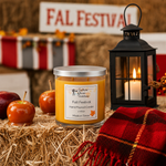 Load image into Gallery viewer, A hand-poured candle labeled Fall Festival in a clear glass jar with a silver lid sits on a bed of straw, styled with caramel apples, a black lantern with a lit candle, and a red plaid blanket. The background features a rustic 'FALL FESTIVAL' sign. Southern Charm Farmhouse.
