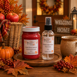 Load image into Gallery viewer, Two handcrafted scented products displayed on a wooden tray in a cozy autumn-themed setting: a red hand-poured candle labeled 'Apple Berry Harvest' and a clear bottle of 'Mulled Cider Press' room spray. The scene is decorated with pumpkins, fall leaves, berries, and a 'Welcome Home' sign in the background. Southern Charm Farmhouse.
