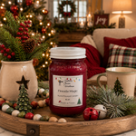 Load image into Gallery viewer, A hand-poured16 oz mason  jar candle labeled 'Fireside Magic' by Southern Charm Farmhouse' sits on a wooden tray in a cozy holiday living room setting with a decorated Christmas tree, mugs, and festive decor.
