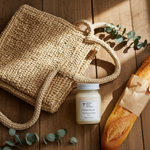 Load image into Gallery viewer, Woven bag, 16 oz Mason Jar French Market Candle, and loaf of bread on a wooden surface with eucalyptus leaves. Southern Charm Farmhouse
