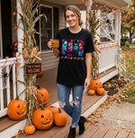 Load image into Gallery viewer, Woman in a 'Color Friends' t-shirt standing on a porch decorated for Halloween with pumpkins and corn stalks. Southern Charm Farmhouse.
