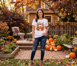 Load image into Gallery viewer, Woman standing in a garden with pumpkins and autumn decorations, wearing a white t-shirt with a graphic design. Southern Charm Farmhouse.
