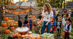 Load image into Gallery viewer, Woman wearing  a Ghost with bats and Pumpkin Shirt with child in costume at a Halloween party with pumpkins and decorations. Southern Charm Farmhouse.

