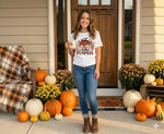 Load image into Gallery viewer, Woman standing on a porch decorated with pumpkins and fall flowers, wearing a t-shirt with a pumpkin design. Southern Charm Farmhouse.
