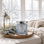Load image into Gallery viewer, A hand-poured scented candle in a clear glass jar with a silver lid sits on a round wooden tray on a windowsill. The candle is labeled 'Jack Frost' by 'Southern Charm Farmhouse'.
