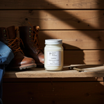 Load image into Gallery viewer, 16 oz Mason Jar of a Leather hand poured candle on a wooden surface with boots and jeans in the background. Southern Charm Farmhouse.
