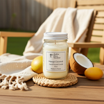 Load image into Gallery viewer, 16 oz Mason jar hand poured candle labeled 'Mango Coconut' on a wooden surface with lemons and a coconut. Southern Charm Farmhouse
