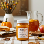 Load image into Gallery viewer, 16 oz mason Jar of mulled cider press candle on a table with fall-themed. Southern Charm Farmhouse. decor
