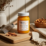 Load image into Gallery viewer, J16 oz mason jar of 'Mulled Cider Press' candle on a wooden surface with cinnamon sticks and a grater. Southern Charm Farmhouse.
