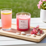 Load image into Gallery viewer, Pink 2 wick hand poured Pink Sands candle, glass of pink lemonade, and flowers on a wooden tray outdoors. Southern Charm Farmhouse.
