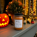Load image into Gallery viewer, 16 oz Mason Jar of 'Pumpkin Hollow' hand poured candle on a porch with Halloween decorations. Southern Charm Farmhouse.
