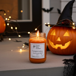 Load image into Gallery viewer, 16 oz Mason Jar hand poured candle labeled 'Pumpkin Hollow' with a carved pumpkin and Halloween decorations in the background. Southern Charm Farmhouse.
