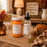 Load image into Gallery viewer, Two fall-themed home fragrance products from Southern Charm Farmhouse displayed on a burlap runner: a pumpkin-scented hand-poured candle in a glass jar and a pumpkin-scented room spray in a clear bottle with a black sprayer. The scene is styled with autumn leaves, pumpkins, a lamp, and a cozy plaid blanket.
