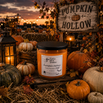Load image into Gallery viewer, A jar hand poured candle labeled 'Pumpkin Hollow' sits in a rustic fall yard scene with pumpkins, lanterns, straw, and a wooden sign. The candle wax is orange and the jar has a black lid. Southern Charm Farmhouse
