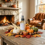 Load image into Gallery viewer, Decorative setup with pumpkins, leaves, and a room spray bottle on a table in a cozy room with a fireplace.  Southern Charm Farmhouse.
