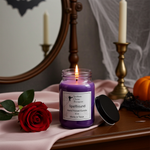 Load image into Gallery viewer, 16 oz mason jar Purple hand poured candle labeled 'Spellbound' on a table with a red rose and decorative items. Southern Charm Farmhouse.
