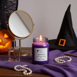 Load image into Gallery viewer, 16 oz mason jar Purple hand poured candle labeled 'Spellbound' with a mirror, pumpkin, and witch hat on a purple cloth. Southern Charm Farmhouse.
