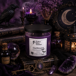 Load image into Gallery viewer, A purple scented candle in a clear glass jar with a black lid sits on a dark tabletop surrounded by witch-themed props including a black raven, old books, candles, crystals, and a lantern. The candle label reads 'Southern Charm Farmhouse' and 'Spellbound'.
