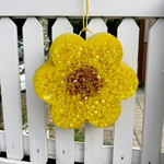 Load image into Gallery viewer, Yellow sunflower-shaped car freshie with a textured surface hanging on a white picket fence. Southern Charm Farmhouse.
