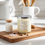 Load image into Gallery viewer, 2 wick hand poured Sweet Vanilla Caramel candle on a wooden cutting board with kitchen items in the background. Southern Charm Farmhouse.
