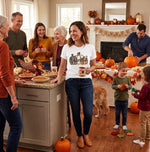Load image into Gallery viewer, Family gathering in a kitchen decorated for Thanksgiving with pumpkins and autumn leaves with woman wearing a white t shirt with three pumpkins on it and the word thankful. Southern Charm Farmhouse.
