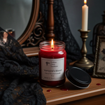 Load image into Gallery viewer, Hand Poured Red candle labeled 'Vampire's Blood' on a wooden surface with dark background. Southern Charm Farmhouse.
