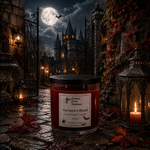 Load image into Gallery viewer, A hand-poured candle in a clear glass jar with a black lid sits on a stone path in a gothic courtyard at night. The label reads 'Vampire's Blood'. Southern Charm Farmhouse.
