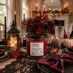 Load image into Gallery viewer, A red scented hand poured candle in a clear glass jar with a black lid sits on a decorated dining table. The label reads 'Vampire's Blood' . Southern Charm Farmhouse.
