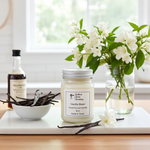 Load image into Gallery viewer, 16 oz Mason jar Vanilla bean hand poured candle with vanilla beans and flowers on a table. Southern Charm Farmhouse
