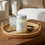 Load image into Gallery viewer, 16 oz Mason Vanilla passion hand poured candle on a woven tray with a glass of iced tea in a cozy living room setting. Southern Charm Farmhouse.
