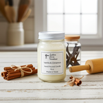 Load image into Gallery viewer, 16 oz Mason Jar of vanilla and cinnamon hand poured candle with cinnamon sticks on a wooden surface. Southern Charm Farmhouse
