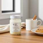 Load image into Gallery viewer, 16 oz Mason Jar of a hand poured candle labeled 'Vanilla &amp; Cinnamon' on a wooden table with a mug and cookies. Southern Charm Farmhouse
