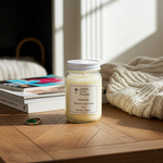 Load image into Gallery viewer, 16 oz Mason jar hand poured Candle labeled 'Volcano' on a wooden surface with books and a blanket in the background. Southern Charm Farmhouse
