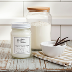 Load image into Gallery viewer, Warm Vanilla Sugar Candle in a 16 oz Mason jar on a wooden surface with a white tiled wall background. Southern Charm Farmhouse.
