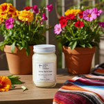 Load image into Gallery viewer, 16 oz Mason Jar hand poured White Tea &amp; Sage candle with a label in front of potted flowers on a wooden surface. Southern Charm Farmhouse.
