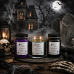 Load image into Gallery viewer, Three Halloween-themed jar candles labeled Spellbound, Witches Brew and Black Magic are displayed on a rustic wooden surface with spooky props including a skull, lantern, tombstones, and skeleton hands. The background shows a haunted house, bare trees, and a full moon. Southern Charm Farmhouse

