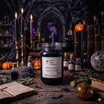 Load image into Gallery viewer, A 16 oz mason jar hand poured candle labeled 'Witching Hour' by Southern Charm Farmhouse., styled on a rustic wooden table with candles, books, a cauldron, lavender, and small pumpkins in a moody Halloween setting.
