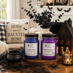Load image into Gallery viewer, Two Halloween-themed jar candles on a wooden tray, styled on a table with a black cauldron, spider decoration, a house lantern, and a cozy living room background. Southern Charm Farmhouse
