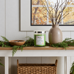 Load image into Gallery viewer, Decorative shelf with a hand poured candle named Cedar &amp; Autumn Leaves, vase, and branches against a wall with a framed picture.  Southern Charm Farmhouse.
