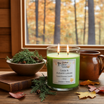Load image into Gallery viewer, Green hand poured candle labeled 'Cedar &amp; Autumn Leaves' on a wooden surface with a window view of trees in autumn.  Southern Charm Farmhouse.
