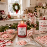 Load image into Gallery viewer, A lit red hand poured candle labeled 'Candy Cane' is displayed on a kitchen counter surrounded by holiday decorations, candy canes, peppermint candies, pine garlands, and a white ceramic Peppermint canister. Southern Charm Farmhouse.
