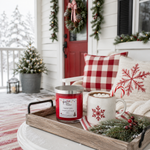 Load image into Gallery viewer, A festive holiday-themed lifestyle scene on a snowy porch. A wooden tray holds a red scented hand poured Candy Cane candle and a white mug filled with a marshmallow hot cocoa drink, set against a cozy backdrop of red and white gingham pillows, a knit throw blanket, and a red front door decorated with a wreath. Southern Charm Farmhouse.
