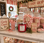 Load image into Gallery viewer, A festive candy shop display on a marble counter with large glass jars filled with peppermint candies, a red jar hand poured Candy Cane candle, candy canes in a glass mug, and vintage-style signs reading 'Candy Shop' and 'Candy Canes 5¢'. Southern Charm Farmhouse.
