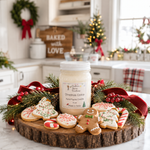 Load image into Gallery viewer, A hand poured candle labeled ' Christmas Cookie' sits on a rustic wood slice surrounded by decorated holiday cookies, greenery, red ribbons, and berries, with a softly blurred kitchen background. Southern Charm Farmhouse.
