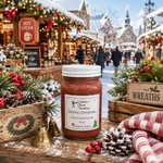 Load image into Gallery viewer, A jar of 'Dickins Christmas' hand-poured candle sits on a snowy wooden table decorated for Christmas, with a festive outdoor market scene blurred in the background. Southern Charm Farmhouse.
