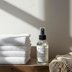 Load image into Gallery viewer, 4 oz. Bottle of Pink Sugar Linen Spray on a wooden surface with white towels in the background. Southern Charm Farmhouse.
