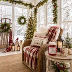 Load image into Gallery viewer, A cozy wicker armchair in a bright, snow-viewed porch setting with a red and beige plaid throw blanket, a matching decorative pillow, a lit candle in a lantern, and a hand poured Home 4 the Holidays candle on a small side table. Southern Charm Farmhouse.
